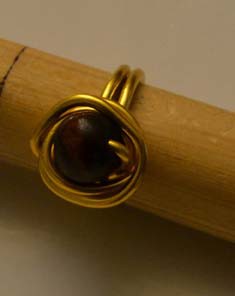 Anillo dorado con bola de madera marrón